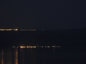 Lights in the distance across the Sea are soft on the hillside.